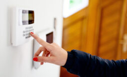 Young-woman-entering-security-code-on-home-security-alarm-system-keypad