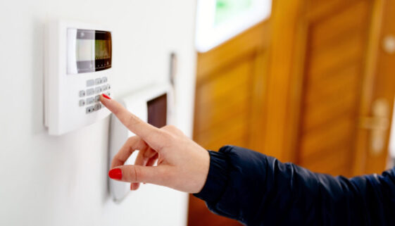 Young-woman-entering-security-code-on-home-security-alarm-system-keypad